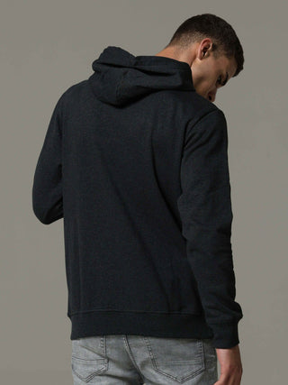 Person wearing a black hoodie from behind on a gray background