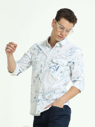 DLAL Indigo color splashed double pocket shirt shop online at Estilocus. 100% Cotton • Full-sleeve indigo splashed printed shirt• Cut and sew placket• Regular collar• Double button edge cuff • Double pocket with flap • Curved bottom hemline . • All double