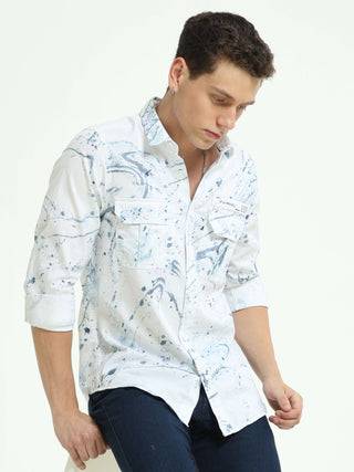 DLAL Indigo color splashed double pocket shirt shop online at Estilocus. 100% Cotton • Full-sleeve indigo splashed printed shirt• Cut and sew placket• Regular collar• Double button edge cuff • Double pocket with flap • Curved bottom hemline . • All double