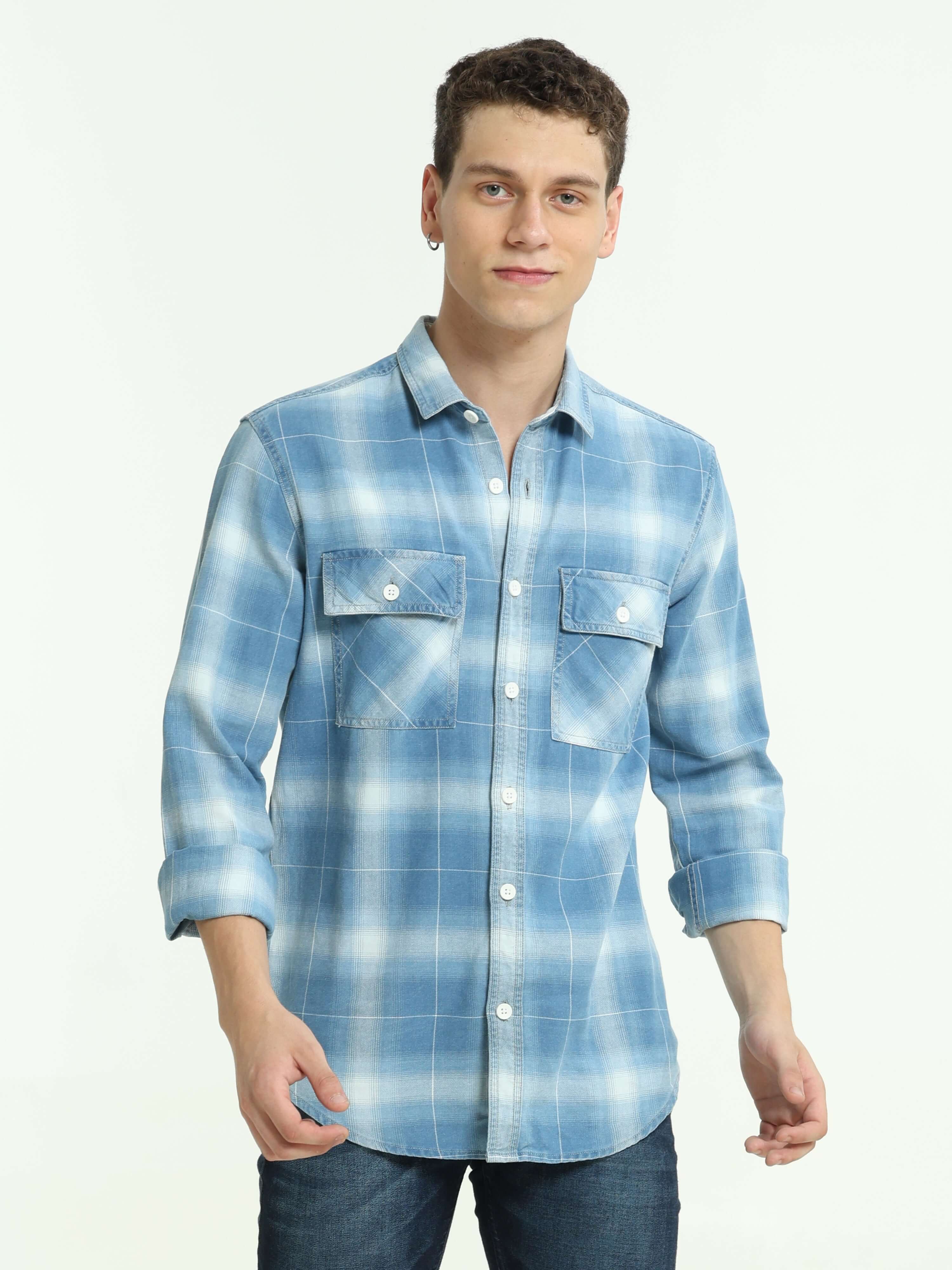 Indigo colored check double pocket shirt shop online at Estilocus. 100% Cotton • Full-sleeve check shirt• Cut and sew placket• Regular collar• Double button edge cuff • Double pocket with flap • Curved bottom hemline . • All double needle construction, fi