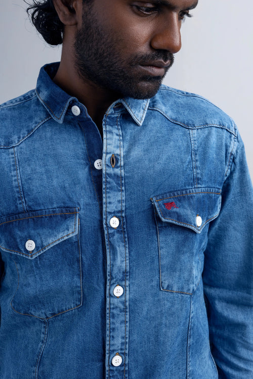 Front view of a man wearing a denim shirt, highlighting its casual style and color.