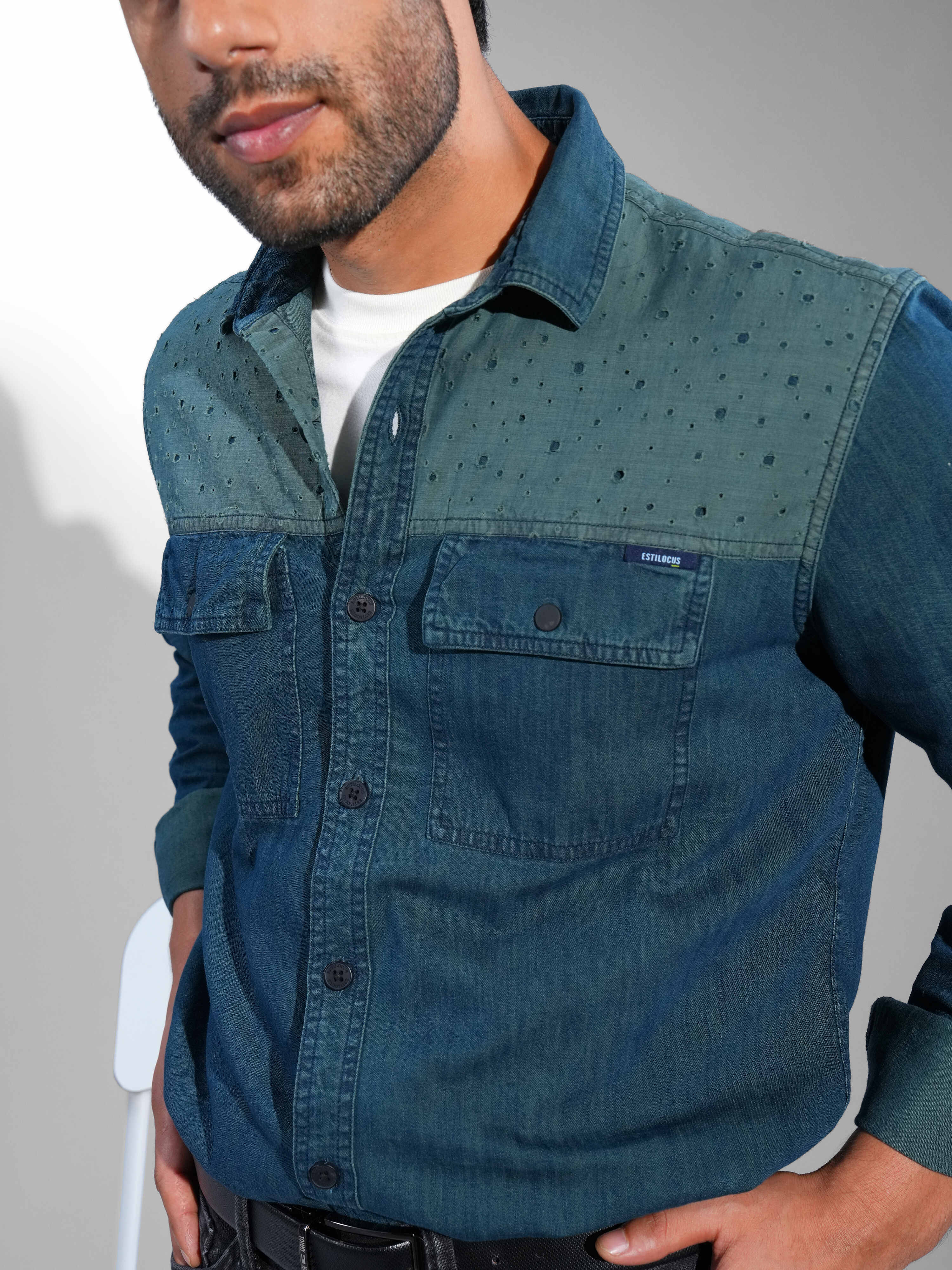 Man wearing a blue denim shirt in a white background.