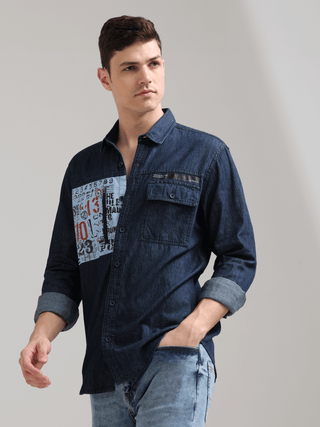 Navy Denim Double Pocket Shirt shop online at Estilocus. Denim ,Full-sleeve shirt Cut and sew placket. Regular collar Double button edge cuff Zipper hidden pocket, other end with flap pocket Curved bottom hemline HD elegant print at pocket All Double need