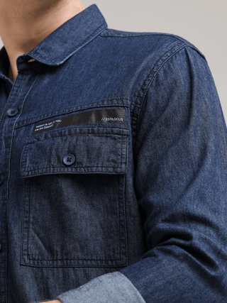 Navy Denim Double Pocket Shirt shop online at Estilocus. Denim ,Full-sleeve shirt Cut and sew placket. Regular collar Double button edge cuff Zipper hidden pocket, other end with flap pocket Curved bottom hemline HD elegant print at pocket All Double need