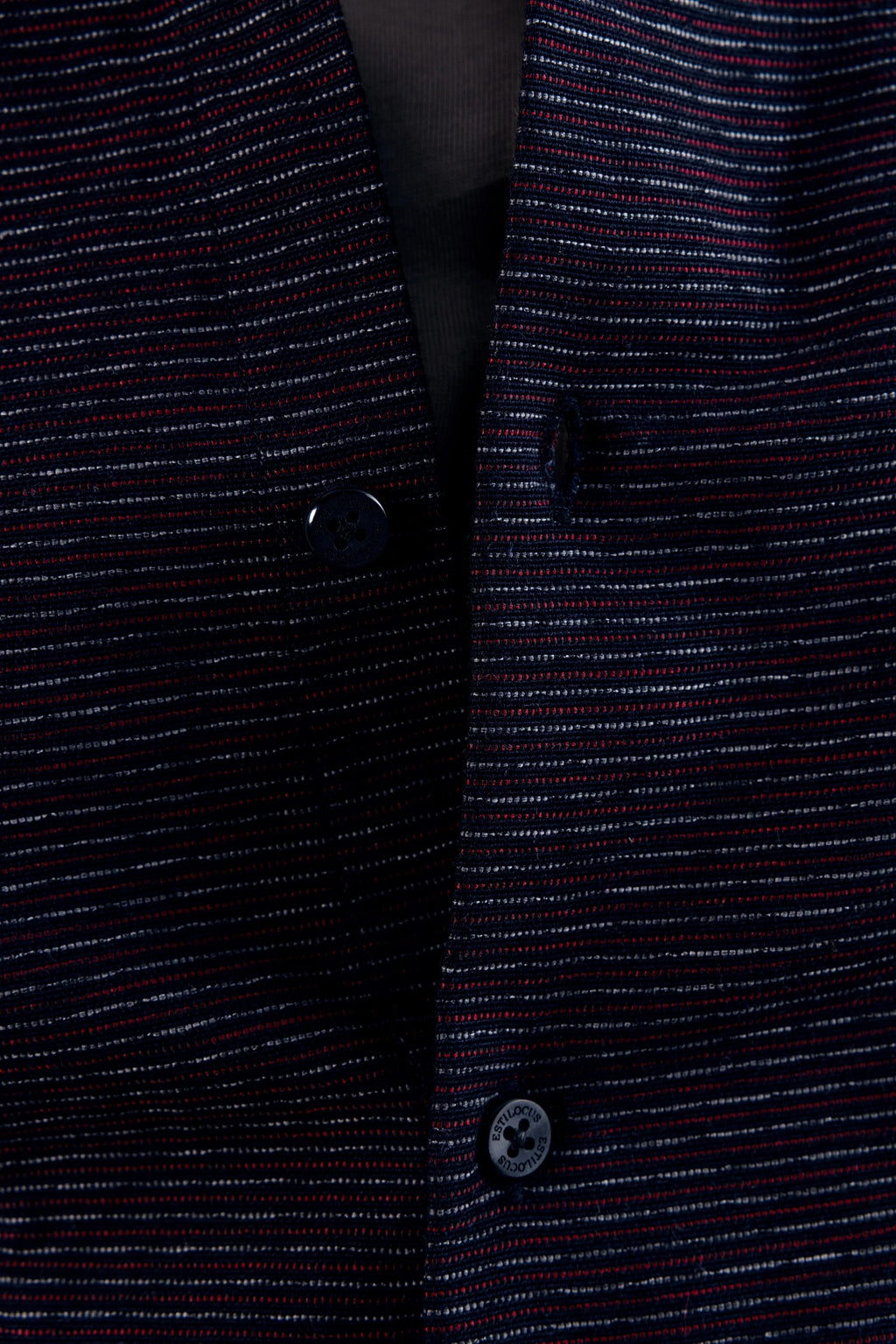 Close-up of a dark blue textured fabric with buttons