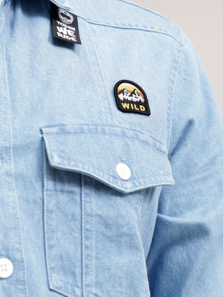 Closeup Short of man wearing light blue denim shirt.