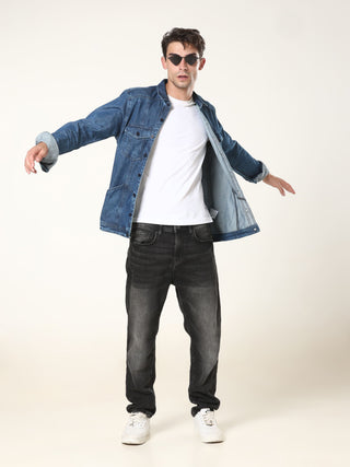 Man wearing a denim jacket, white t-shirt, black jeans, and sunglasses on a white background