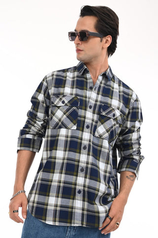 Man wearing a plaid shirt with rolled-up sleeves on a white background.