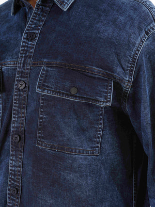 Close-up of a blue denim shirt with a pocket.