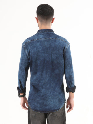 Person wearing a blue denim shirt and showing backside of the denim shirt on a white background.