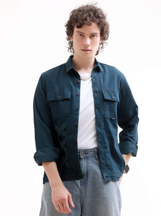 Man wearing a dark blue denim jacket over a white shirt on a white background.