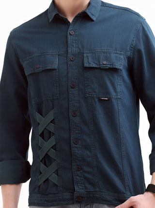 Blue denim shirt with criss-cross design on a white background.