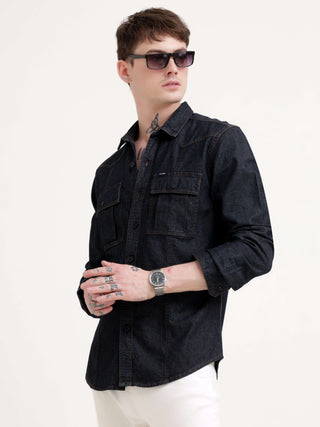 Man wearing a black denim shirt and sunglasses on a white background.