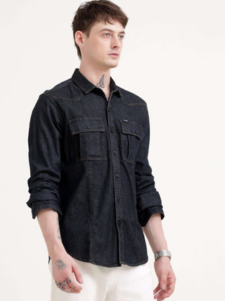 Man wearing a black denim shirt on a white background.