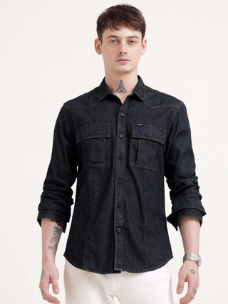 Man wearing a black denim shirt on a white background.