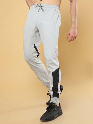 Gray Joggers shop online at Estilocus. •High GSM knitted breathable fabric. •Elastic waistband with an adjustable draw cord secures your fit • Bottom rib with patch unique design. • Welt hand pocket Fit : Comfort fit Size : The model is wearing M size Mod