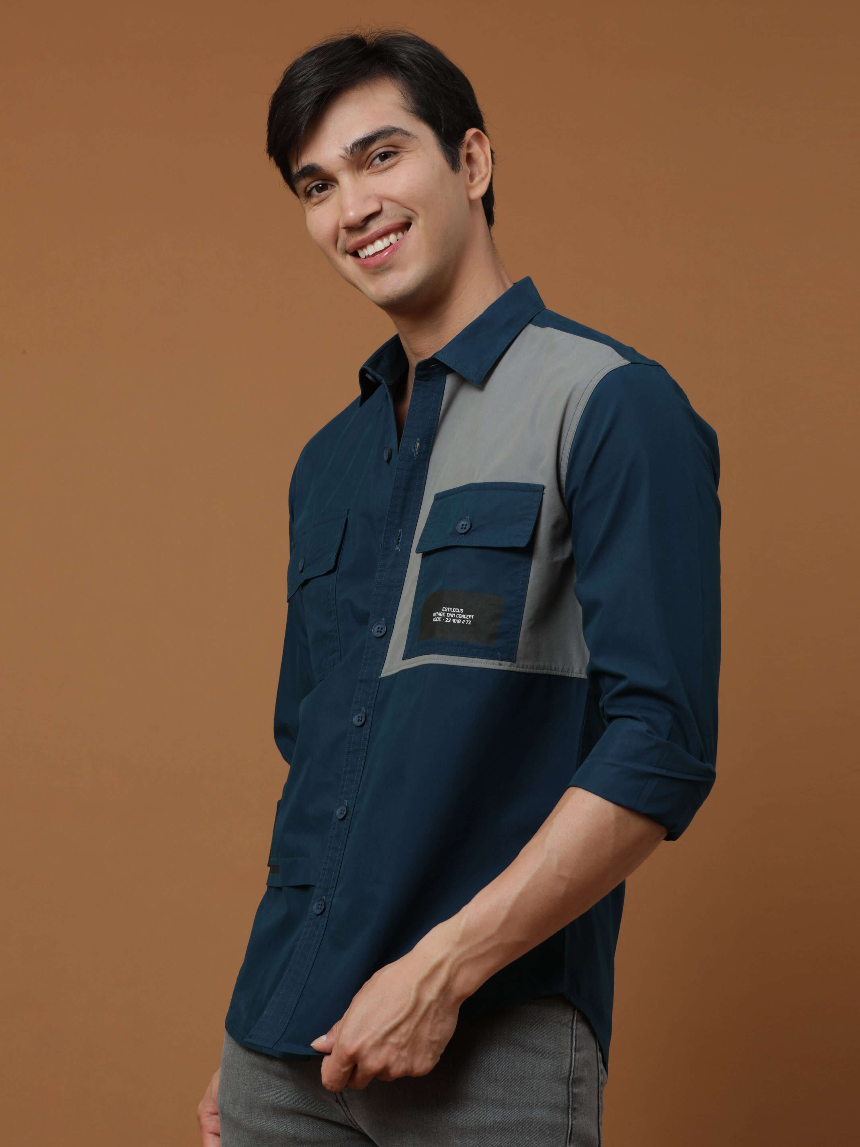 Teal Blue Contrast Patch Cargo Shirt shop online at Estilocus. 100% Premium peach Cotton Full-sleeve solid shirt Cut and sew placket Contrast patch @ Front panel pocket Regular collar Double button edge cuff Double cargo pocket along with HD brand print C